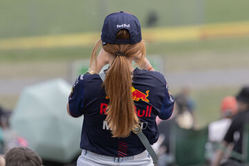 Obraz premium Spielberg, Austria: Formula 1 Red Bull Racing fan in a red shirt and a red cap on the Red Bull Ring Race track during the Austrian Grand Prix