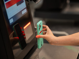 Woman scanning discount on phone at self-checkout. 