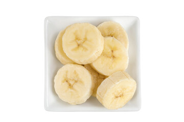 peeled banana pieces in ceramic bowl isolated on white background. Top view. Flat lay.