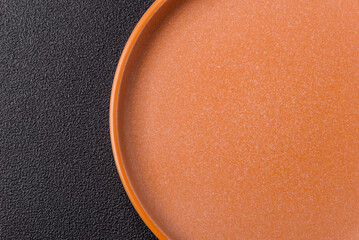 Empty round black plate for food, kitchen utensils on dining table. Empty plate