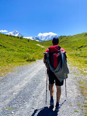 Solo Hiker Walking Toward Snow-Capped Mountains on a Sunny TMB (Tour du Mont Blanc) Trail. Vertical