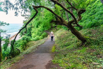 Tourist woman walking through the forest of Mount Urgull in San Sebastian, Spain.