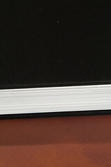 Black Hardcover Book on Brown Surface
