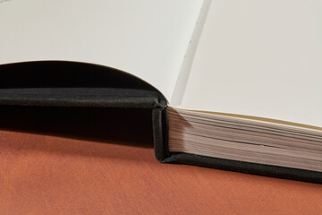 Black Hardcover Book on Brown Surface
