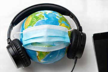Globe with face mask and headphones on white background	