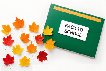 Back to school text with autumn leaves and green notebook	
