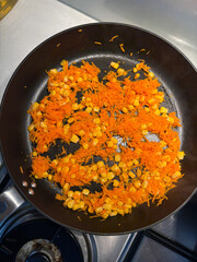 Carrot and corn on the frying pan.