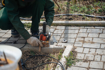 A man cuts off a piece of metal with a grinder.