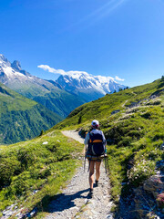 Solo Hiker Walking Toward Snow-Capped Mountains on a Sunny TMB (Tour du Mont Blanc) Trail in Alps. Vertical
