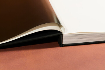 Open Hardcover Book on Brown Background
