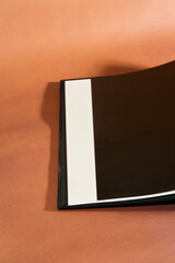 Open Hardcover Book on Brown Background
