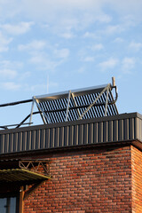 Solar panels on brick building roof under clear sky