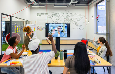 Modern workplace with virtual meeting of multiethnic coworkers