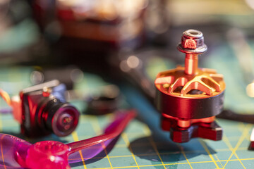 FPV drone components including motor and camera on workbench with tools and propeller © HannaStudio