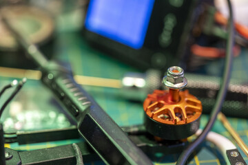 Close-up of FPV drone motor and tools on electronics workbench