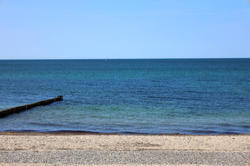 Tranquil waves roll onto the Baltic Sea shore under a wide open sky — a peaceful moment by the...