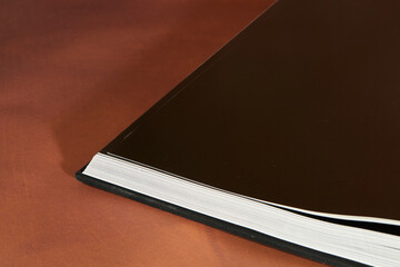 Open Book with Glossy Pages on Brown Table
