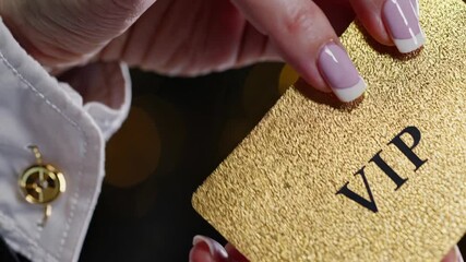 Elegant businesswoman showing a golden vip card, suggesting exclusivity, privilege, and access to premium services or events, against a blurred background