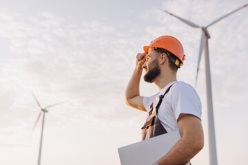 Arab engineer inspecting wind turbines in the desert for sustainable energy