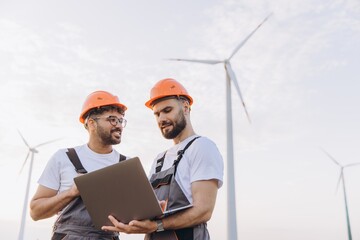 Engineers working on a laptop in a wind turbine power plant