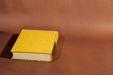 Yellow Marbled Book on Brown Surface
