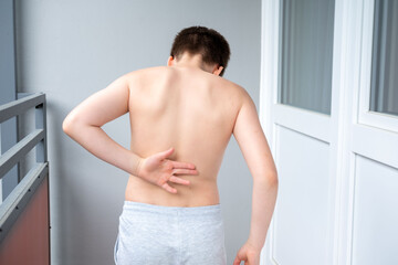 Child's back, boy, child 11 years old grabbed sore spot, curved spine, scoliosis, orthopedic or...