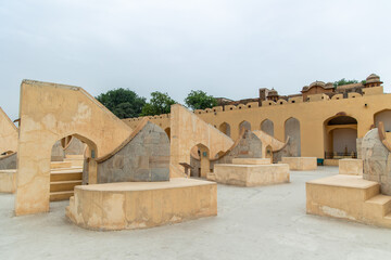 Jantar Mantar astronomical observatory showing architectural instruments under cloudy sky in Jaipur, India