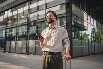 one man with beard and eyeglasses walk with suitcase and use phone