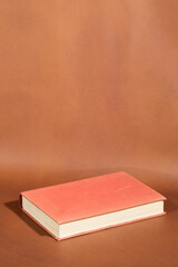 Book with Red Cover on Brown Surface

