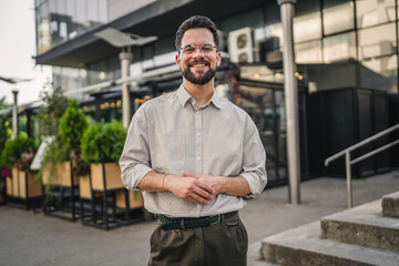 Portrait of man with beard and eyeglasses stand in the street