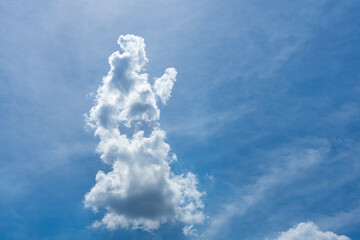 A single fluffy cloud drifts peacefully across the clear blue sky, adding softness to the vast open...