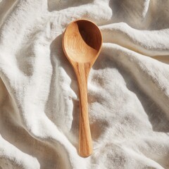 Craftsmanship shines through a solitary wooden spoon resting on soft linen, inviting culinary creativity and warmth