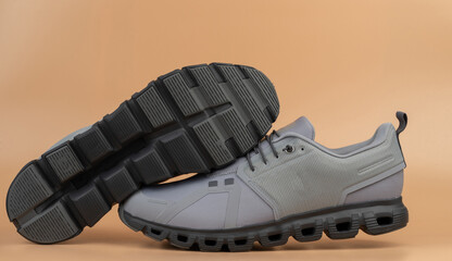 Stylish grey athletic shoes positioned on neutral background for modern look