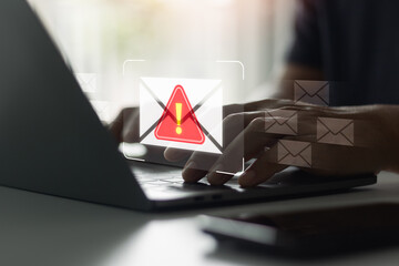 Phishing email warning alert on laptop screen with hands typing, concept of cyber scam, digital...