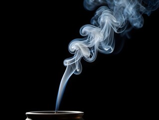 Stock photo of incense smoke rising gracefully on black background for meditation and relaxation