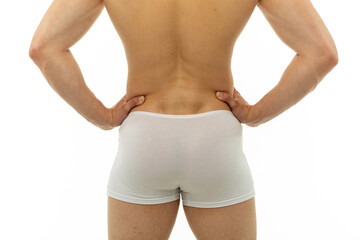 athletic guy in white tight boxer shorts standing with his back on isolated background. men's...