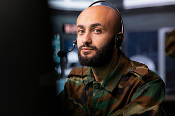 Military specialist reporting battlefield information to army decision makers using headset...