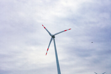 Wind turbine turn by cloudy sky close up, front view