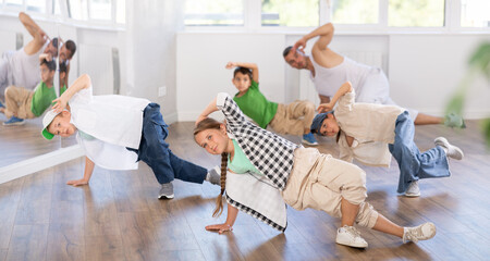 Group of active children dancers having break dance training at dance studio