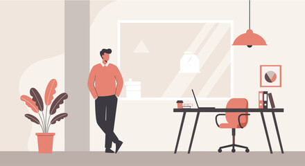 A young man leans against a wall in a modern office space with a desk, laptop, and plant, creating a minimalist and professional atmosphere for work.