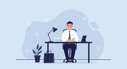 A focused businessman sits at his desk, writing and working on a laptop in a modern office setting.