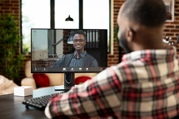 African american employee in home office speaking with company manager on video call, discussing...
