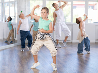 Girls and boys performing hip-hop dance training hall during group dancing classes