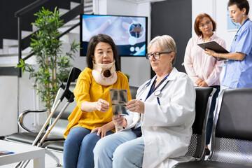 Doctor examining woman patient with neck fracture during routine appointment in modern clinic...