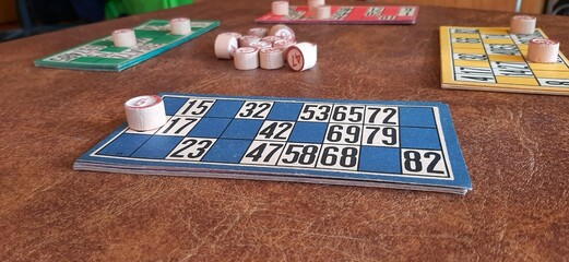 Close-up of a blue lottery card with numbers marked by wooden balls, showing the progress of a game...