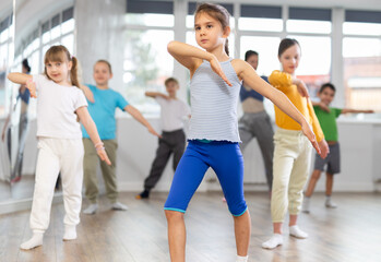 Group of boys and girls rehearsing modern dance in studio