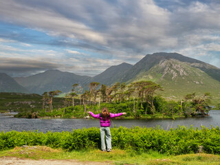 Young girl tourist looking at stunning nature scenery of Connemara, county Galway, Ireland. Lake,...