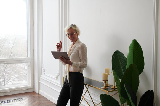 Senior business woman chatting with colleagues in zoom