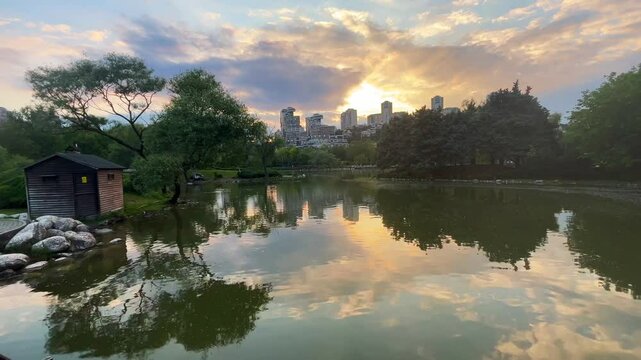 Lake park view and behind modern buildings silhouette at sunset in Istanbul, Turkey. (4K video)