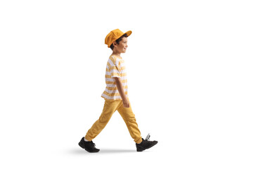 Full length profile shot of a boy with a yellow cap walking